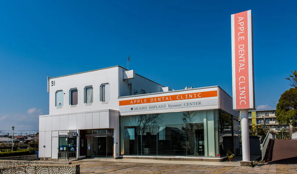 建物の外観と「APPLE DENTAL CLINIC」の看板