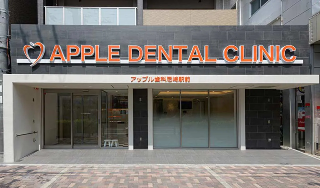 建物正面の入口と「APPLE DENTAL CLINIC」の看板
