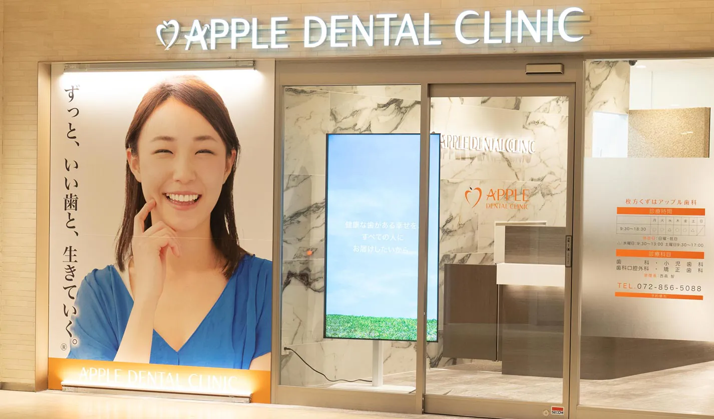 医院の入口と「APPLE DENTAL CLINIC」の看板
