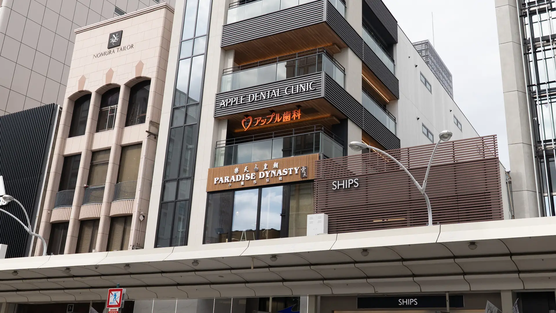 医院が入る建物と「APPLE DENTAL CLINIC アップル歯科」の看板