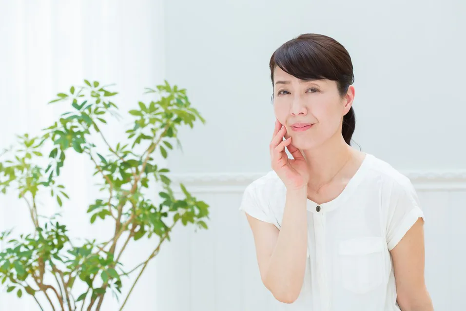 頬に手を当てる女性