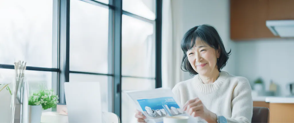窓辺の席でパンフレットを開いている女性